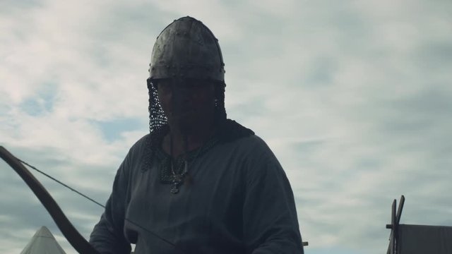 Medieval Archer Draws a Bowstring, Aims and Makes a Shot. Medieval Reenactment. Shot on RED Cinema Camera in 4K (UHD).