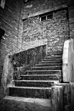 The strange staircase leading into brick wall. Black and white p