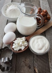 Ingredients for baking - milk eggs cheese nuts flour wheat, wood background