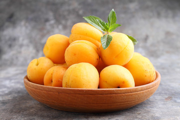 apricots in a wooden plate with mint leaves