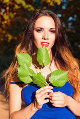 Beautiful young girl holding leaves in hands