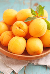 apricots in a wooden plate with mint leaves