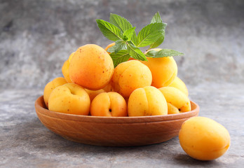 apricots in a wooden plate with mint leaves
