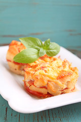 chicken baked with tomatoes and cheese in a white plate on a blue background
