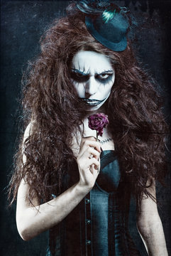 Woman in image of gothic freak clown with withered flower. Grunge texture effect