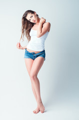 Fashion shot: beautiful young woman in denim shorts and shirt. Full length
