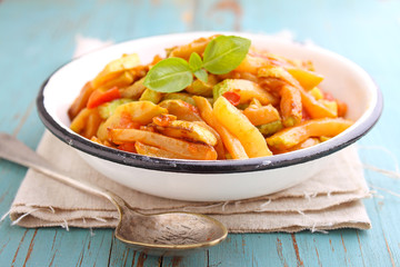 ragout of zucchini and tomato with garlic and basil, in a white plate, selective focus