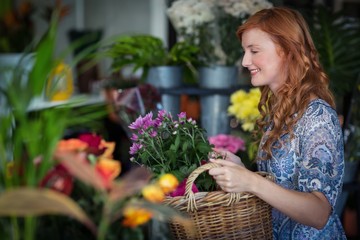 Female florist holding basket of flowers