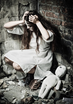 Horror style shot: strange crazy girl and her moppet doll