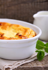 Cottage cheese casserole in white dish, on a blue background