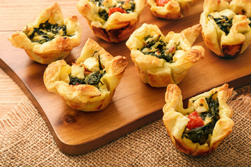 Appetizer - tartlets with spinach, feta, tomatoes, cheese and garlic.