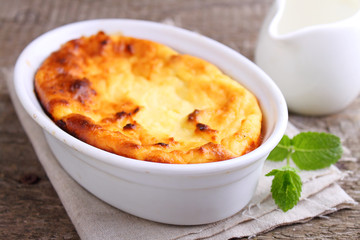 Cottage cheese casserole in white dish, on a blue background