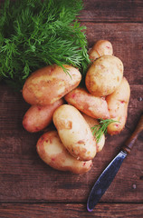 young potatoes in a wooden plate on a wooden background
