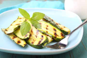 zucchini grilled on a blue plate with basil, selective focus.