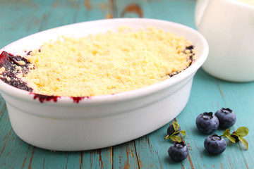 crumble with blueberry, bilberry in white plate
