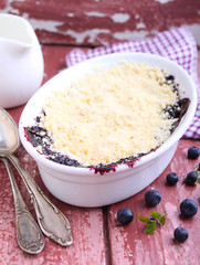 crumble with blueberry, bilberry in white plate