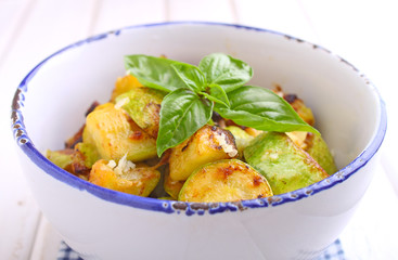 fried zucchini with garlic and basil in white plate