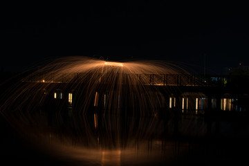 Showers of hot glowing sparks from spinning steel wool.
