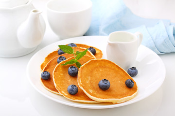 Pancake with berries blueberries in a plate on a white background