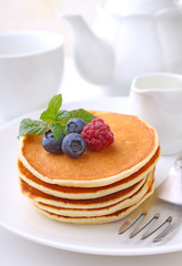 Pancake with berries blueberries in a plate on a white background