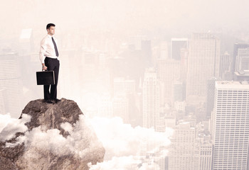 Happy businessman standing on stone top