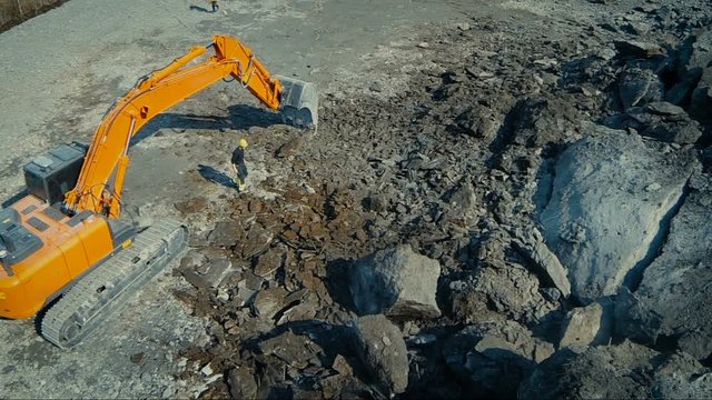 Aerial drone shot of a excavator working in construction yard