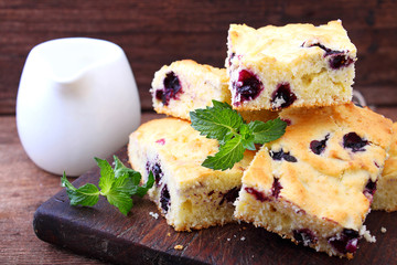 cake with blueberries cut into slices on old wooden board