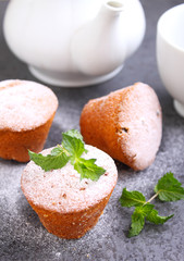 Sponge cakes with raisins decorated with powdered sugar and mint leaves