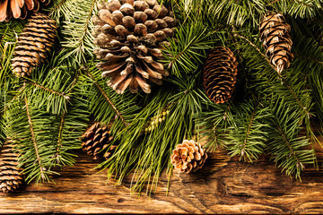 Christmas background. Fir tree branches and cones on wood