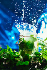 Bank mojito with lime and mint ice cube falling splash