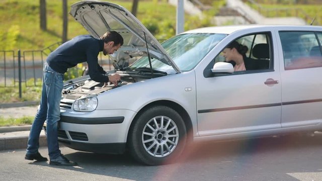 Woman help to man repair broken car