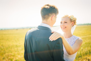 the bride and groom on the background of field