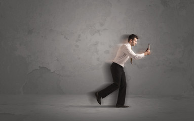 Running businessman with device in hand
