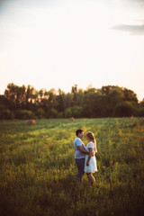 love story man and woman on the background of haystacks sun