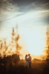 Fototapeta na wymiar love story man and woman on the background of haystacks sun