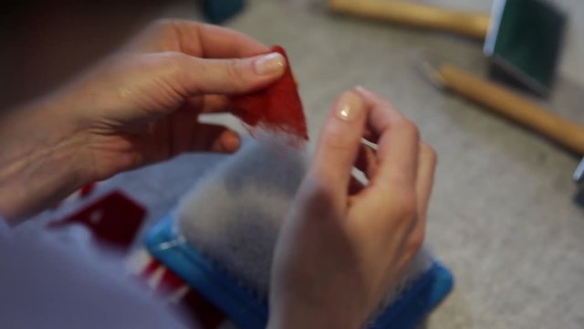 Сворачивание заготовки из шерсти в процессе работы над войлочным изделием
