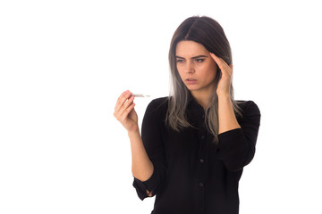Woman with headach holding a thermometer
