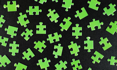 Green puzzles on a black leather
