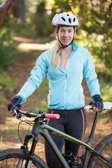 Obraz premium Portrait of female mountain biker with bicycle