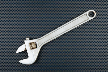 Adjustable wrench on a background with perforation of round hole