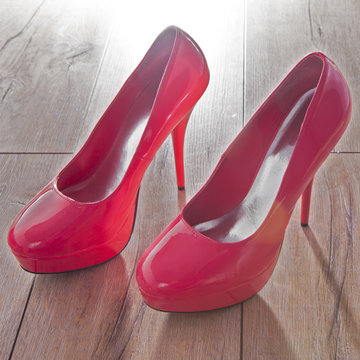 Red women shoes on wooden background.