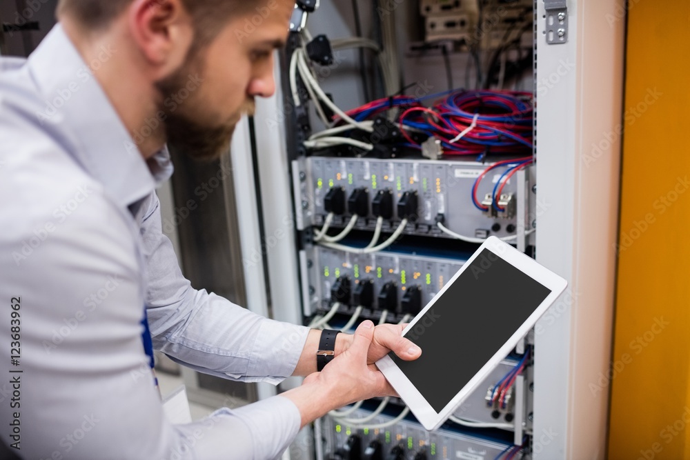 Fototapete Technician using digital tablet while analyzing server