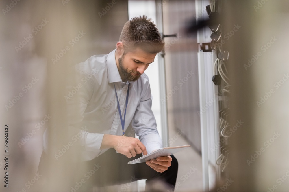 Aufkleber Technician using digital tablet while analyzing server