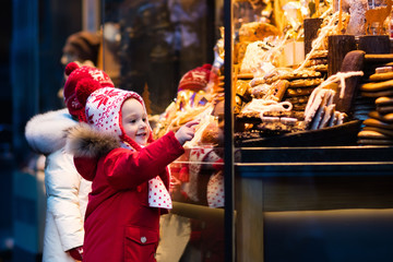 Kids looking at candy and pastry on Christmas market