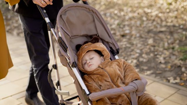 Parents walks in the city in the warm autumn weather with the child.