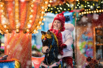 Obraz premium Child riding carousel on Christmas market