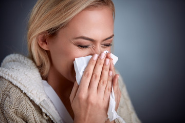 Woman holding handkerchieif blowing nose