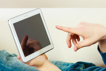 Young man with digital tablet laying on couch