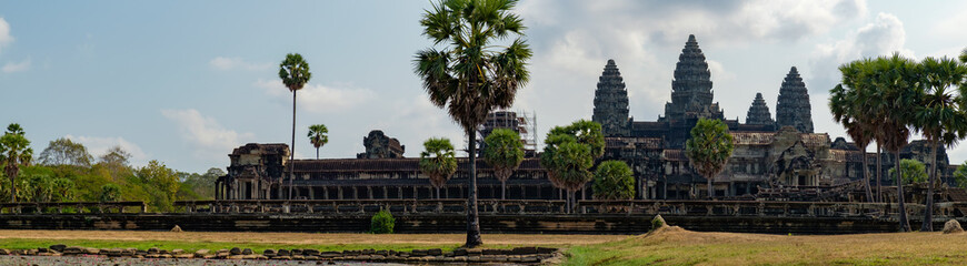 Panoramic view of ancient ruins of temple complex Angkor Wat seen across the pond with lilies, Siem Reap, Cambodia.