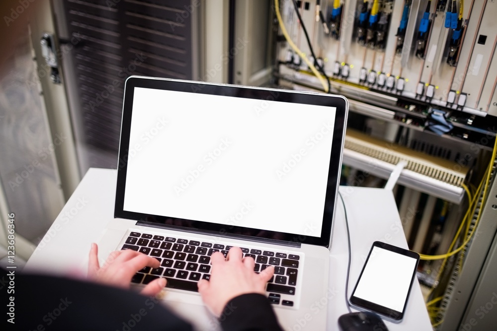 Aufkleber Technician using laptop while analyzing server